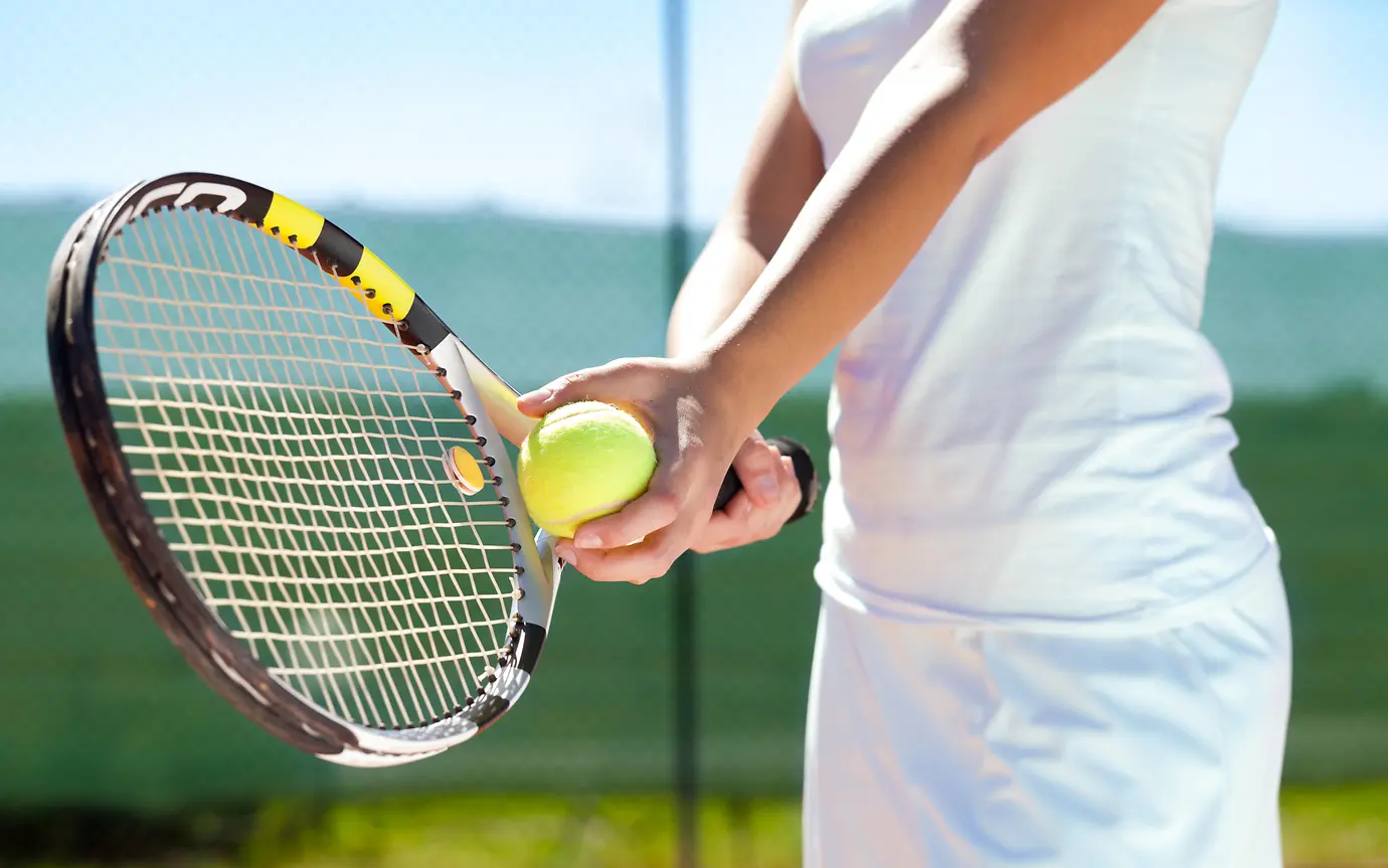 Player holding tennis racket and ball