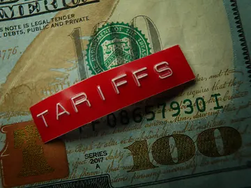 Red tariffs label on a hundred dollar bill 